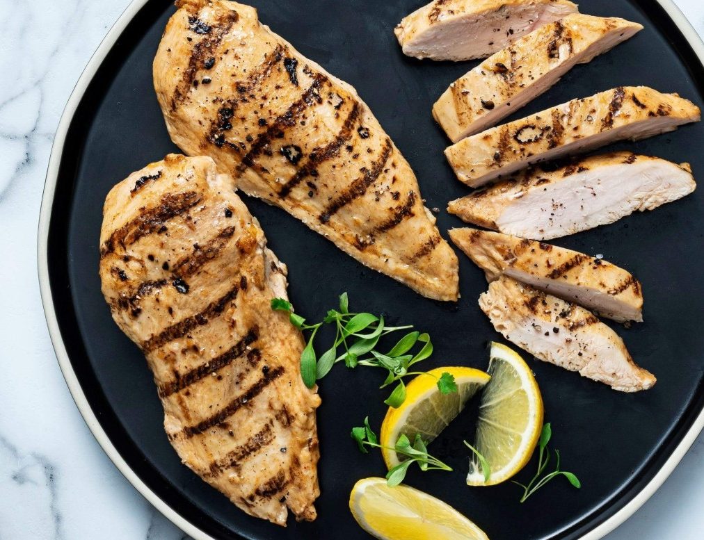Seared Grilled Chicken Breast with lemon wedges