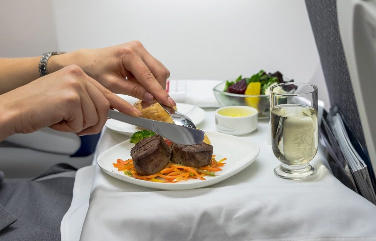 Femme mangeant un steak dans un avion