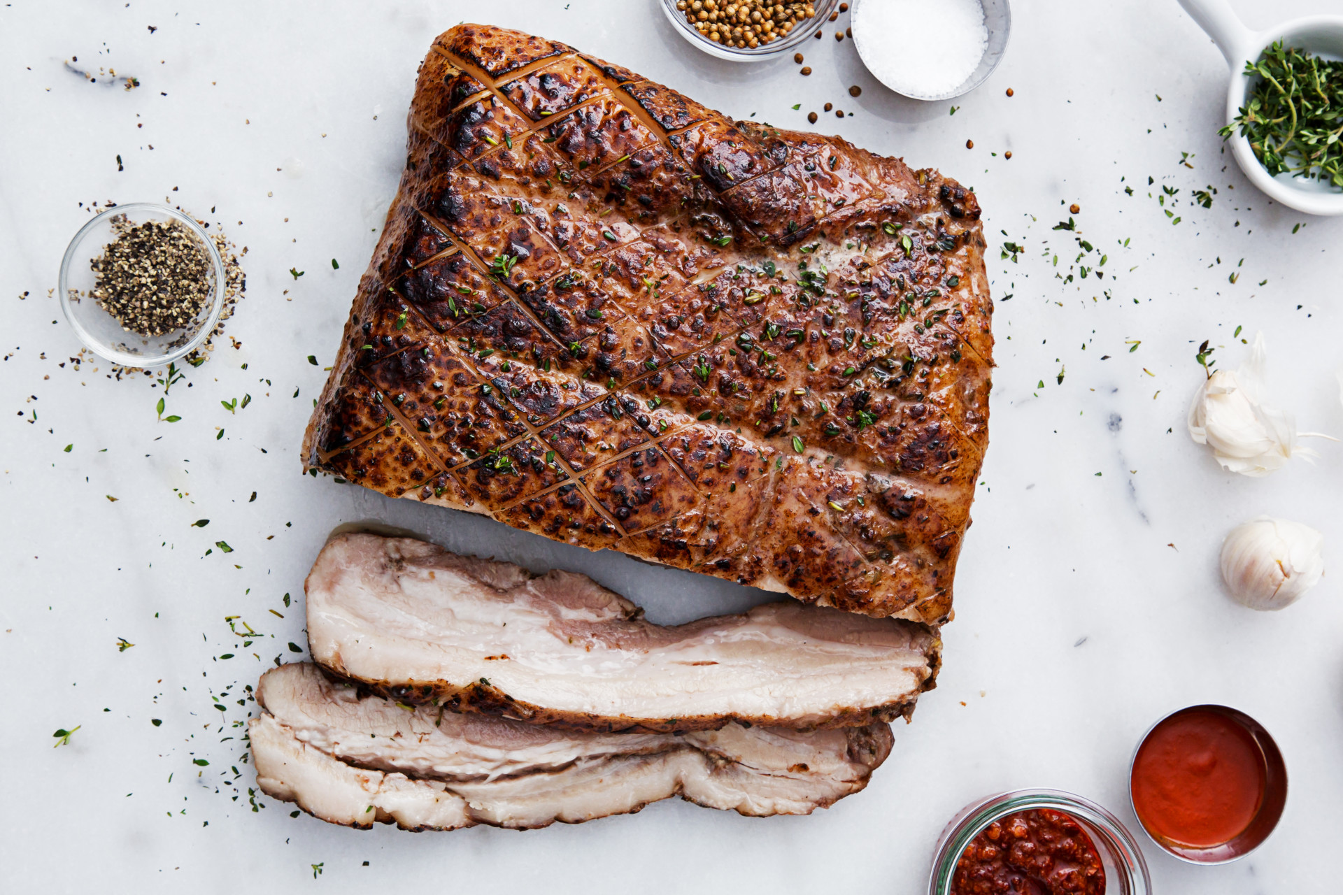 Thinly cut pork belly on table with sauces and spices
