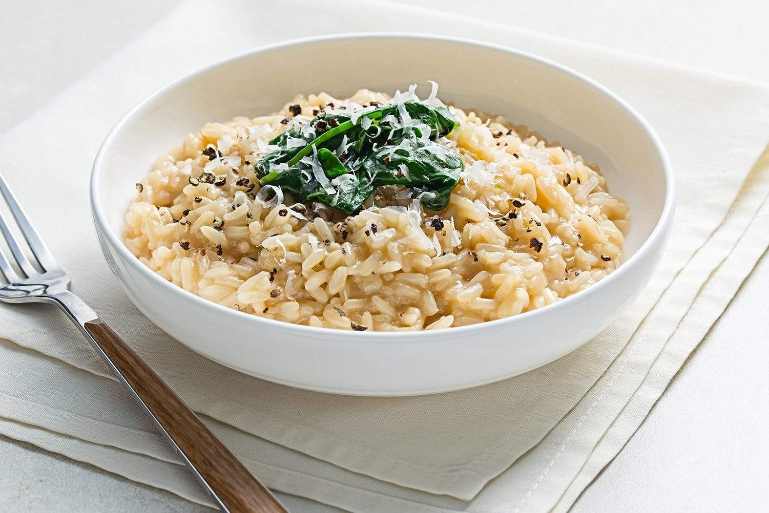White Wine Risotto in bowl with green vegetable topping