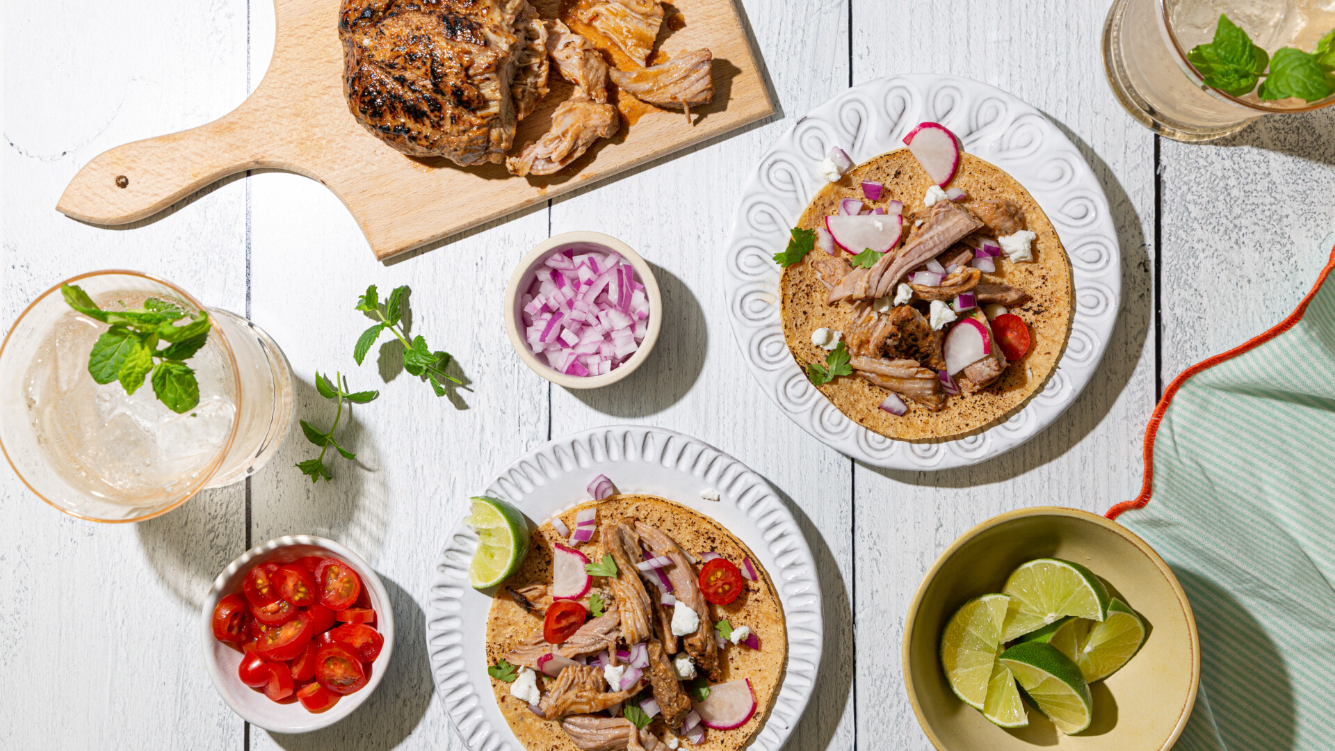 Tacos and a mix of ingredients on a white background